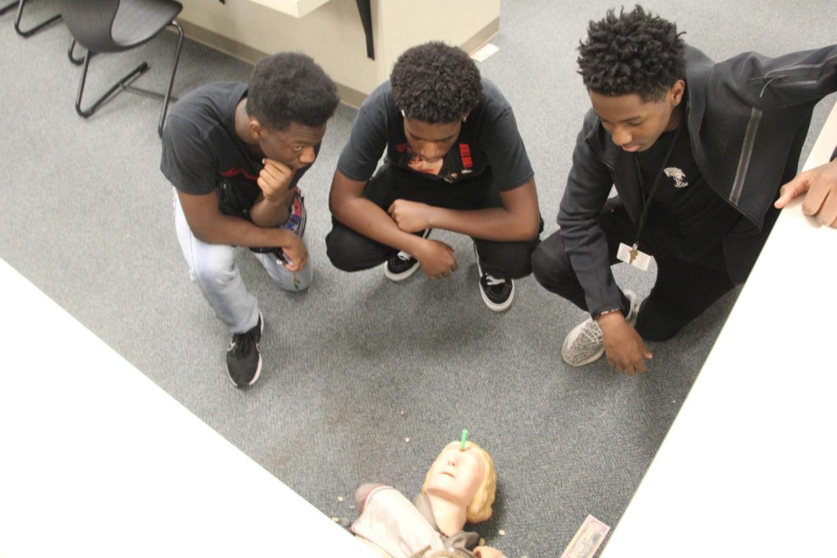 Students examine a crime scene during a criminal justice class. 