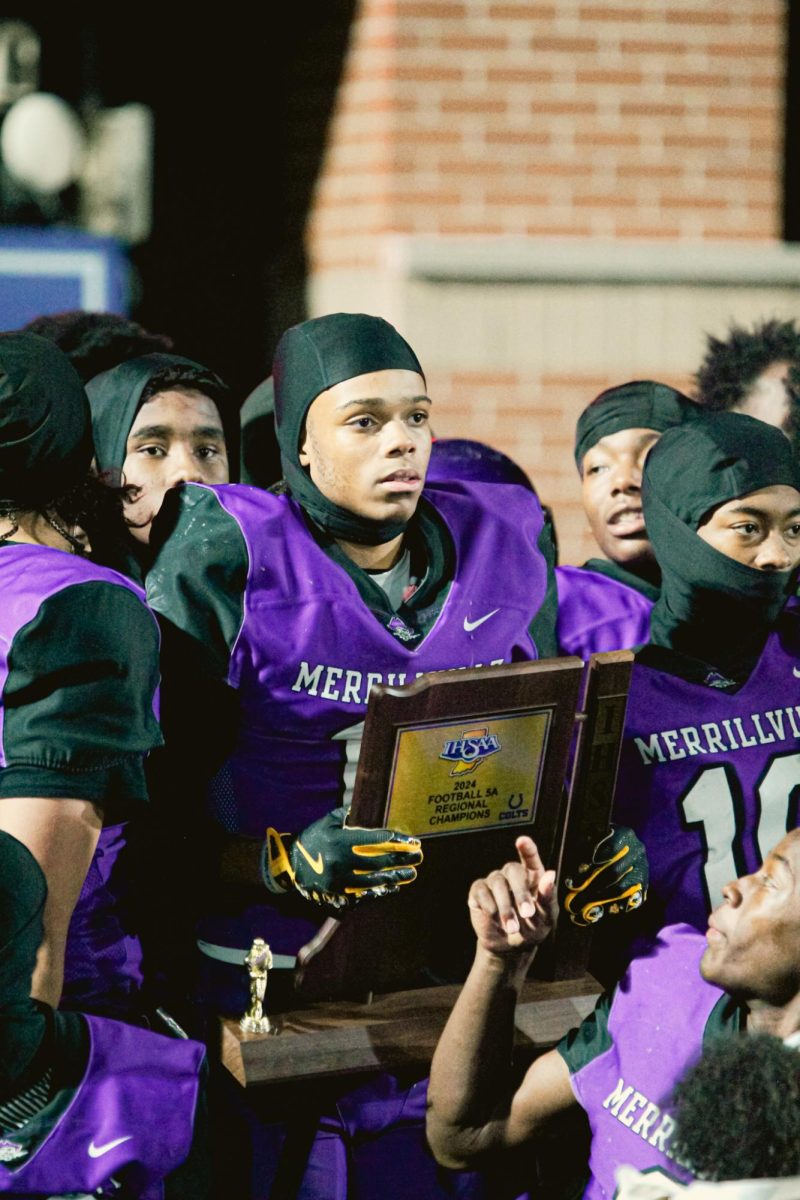 John Peters holds up 2024 Football Regionals' trophy.