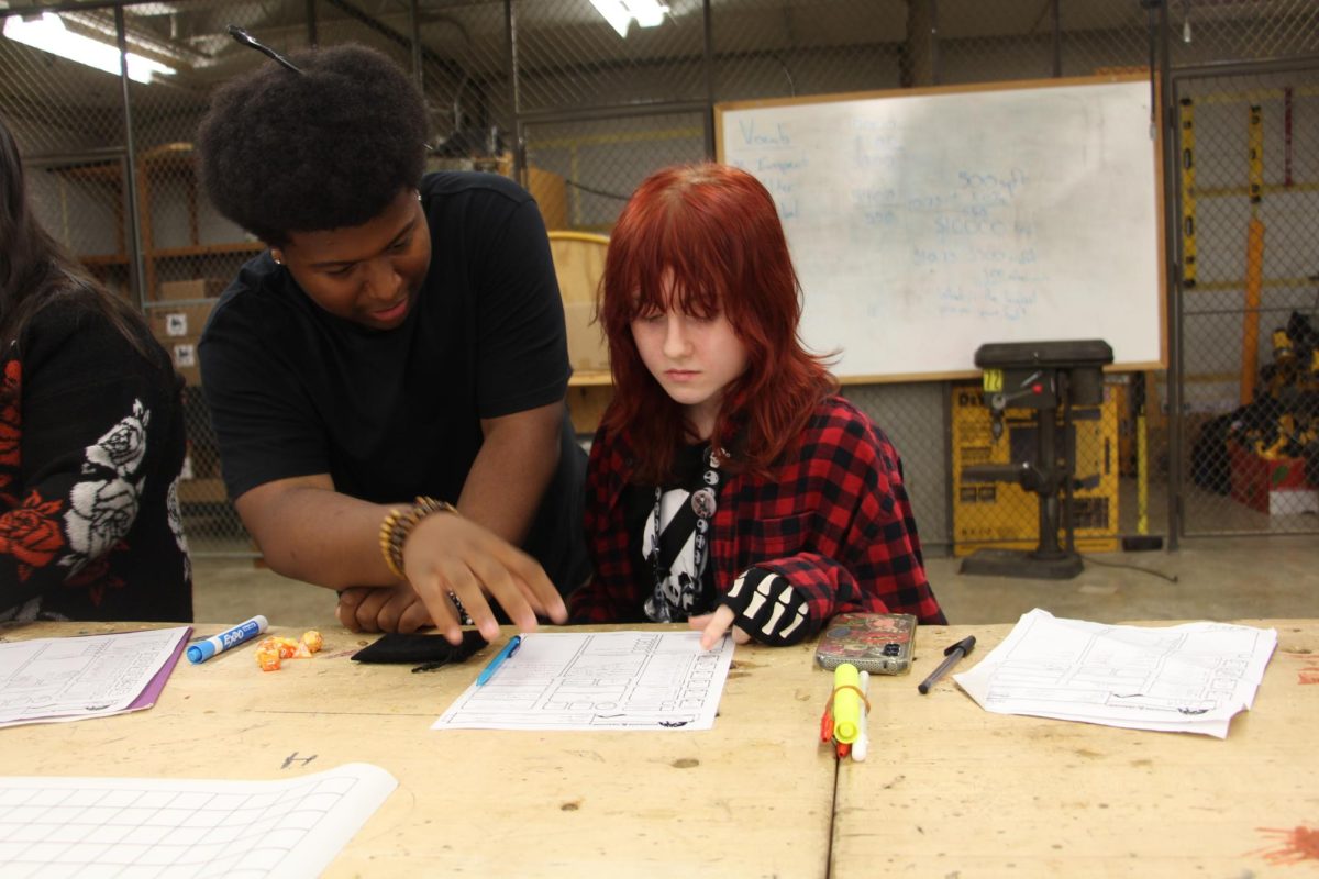 Bryson White reviews the rules with newcomer Nikki Martin at a Dungeons & Dragons meeting.