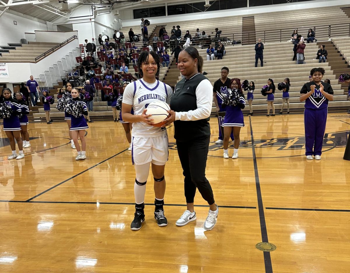 Kylie Wells accepts a commemorative ball after scoring her 1,000 point the previous night.