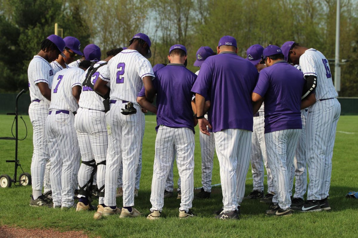 The baseball team comes together for a prayer before a game against Wheeler.