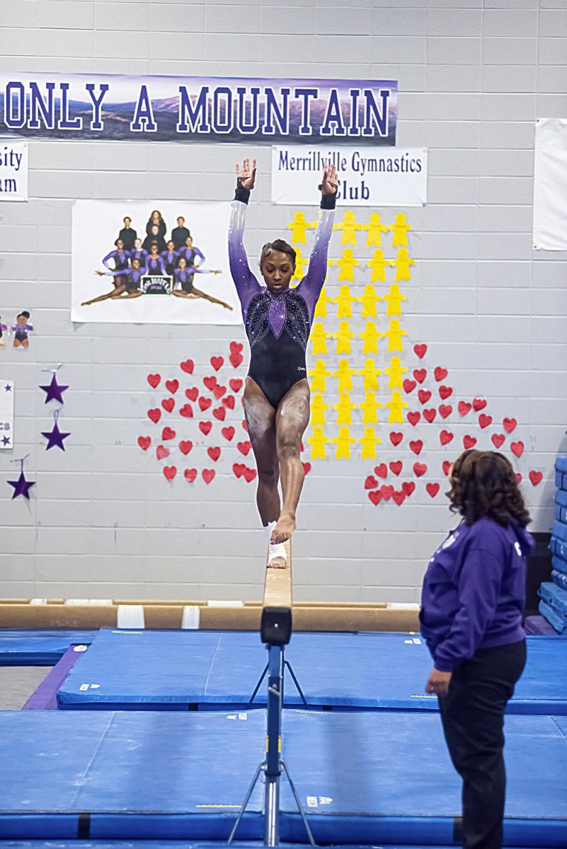 Senior Saniya Lipscomb prepares to flip on the balance beam. 