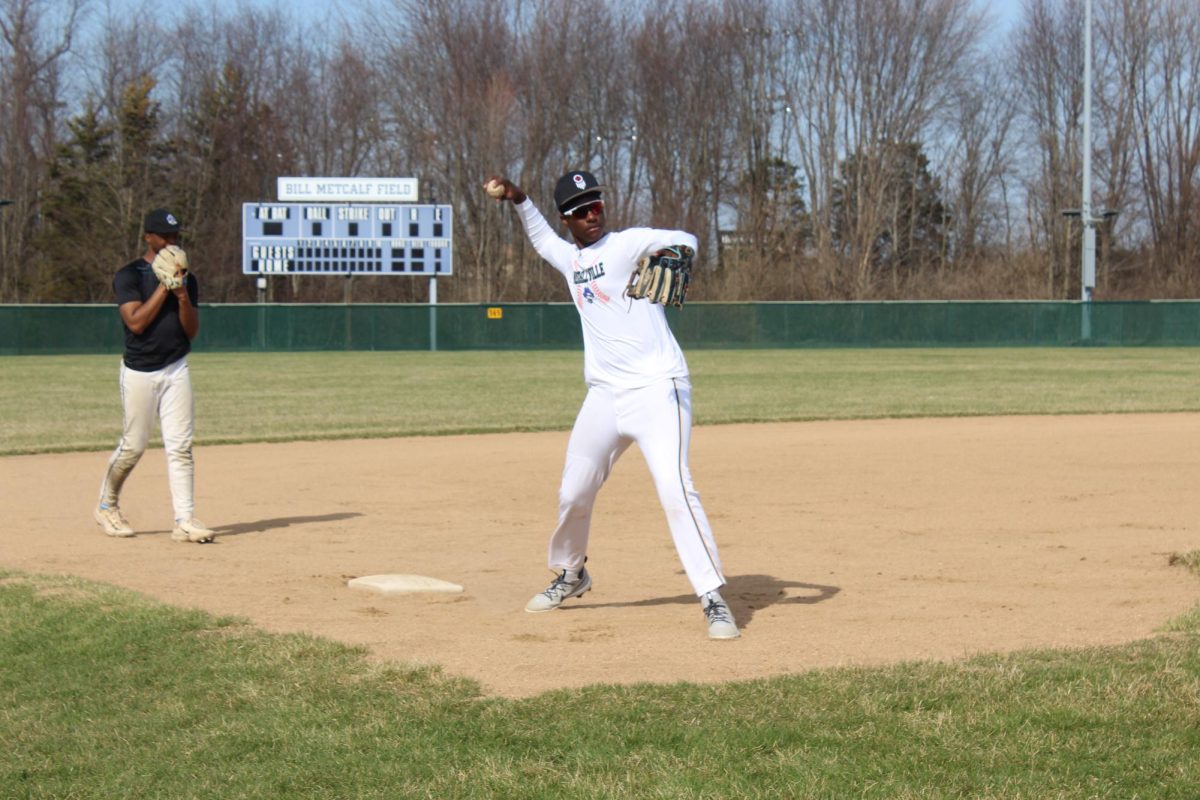 Evan Goodwin fields a grounder at third as Senior Kaleb Henry watches during practice this week.