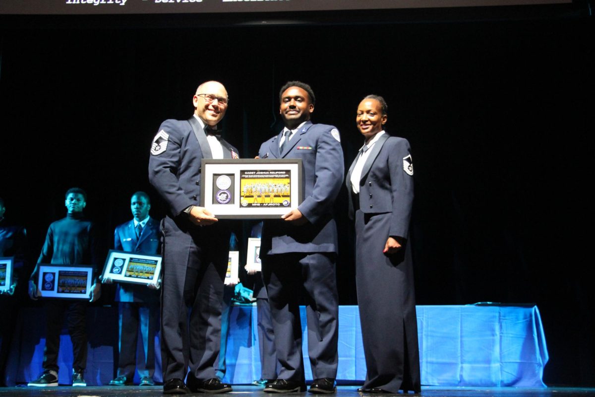 At the recent military ball, CMSgt. James Ponziano and Sgt. Karen Allen honor Josh Reliford with a special plaque for senior cadets.